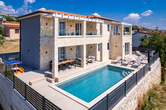 Moderne Villa mit Pool, Sonnenterrasse und Blick auf die umliegende Landschaft.